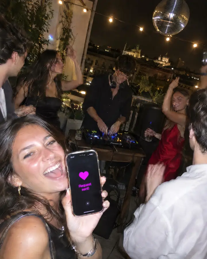A private house party with a DJ and a group of friends requesting songs on their phones.