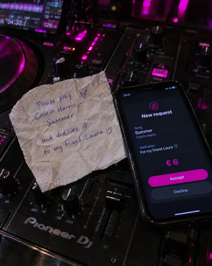 On the mixer, a crumpled napkin with a request scribbled in pen next to a phone showing the tidy WeSound request: song, dedication and €6.