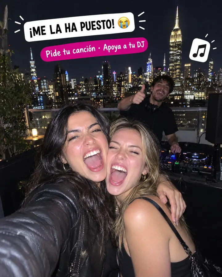 Foto tipo Story en una azotea de Nueva York: dos amigas gritan abrazadas bajo el texto «¡Me la ha puesto!» y el DJ levanta el pulgar detrás.