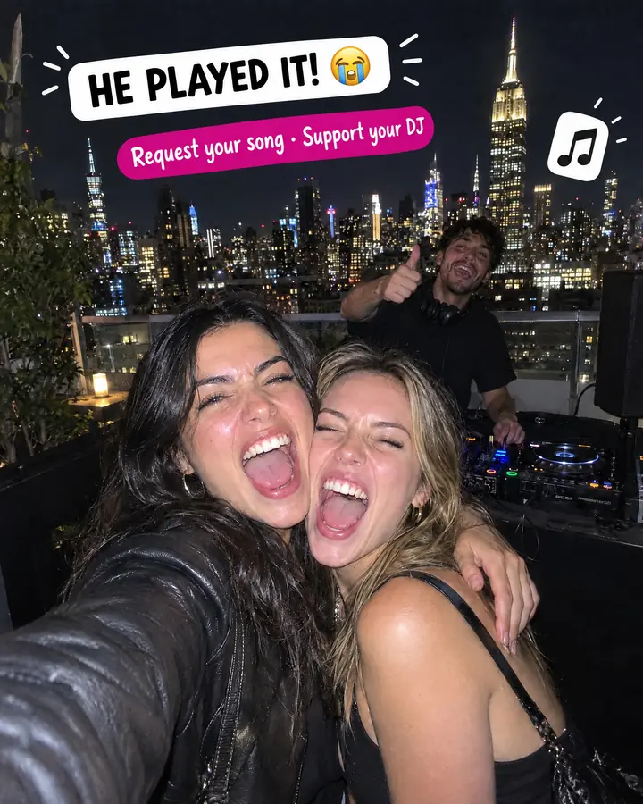 Story-style photo on a New York rooftop: two friends hug and scream under the text "He played it!" while the DJ gives a thumbs up behind them.